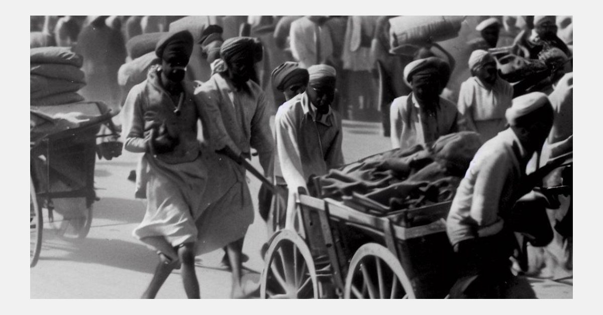 A group of men pushing a cart with a person